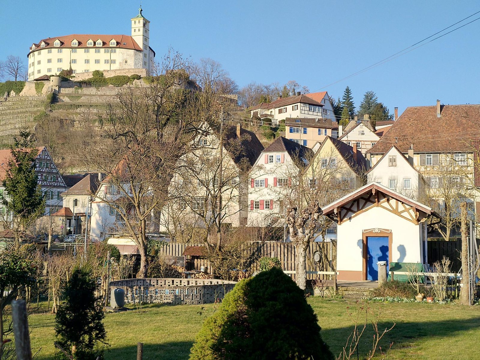 Bürgergärten mit alten Gartenhäuschen in der Enzaue von Vaihingen, im Hintergrund die Burg