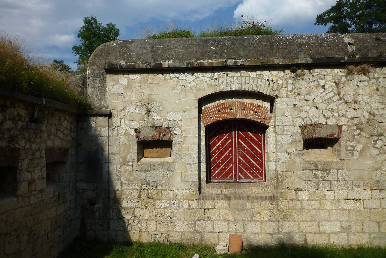 Festungsmauer mit rotem Tor in der Ulmer Friedrichsau