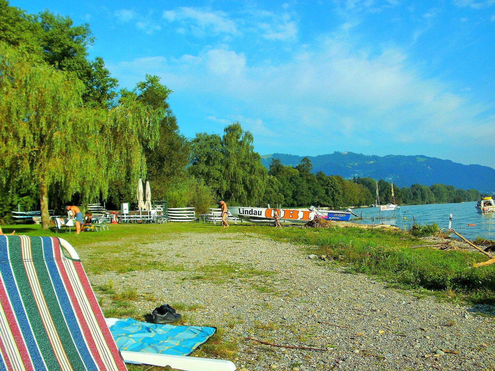 Kiesufer und Liegewiese im Strandbad Eichwald in Lindau mit Blick über den Bodensee