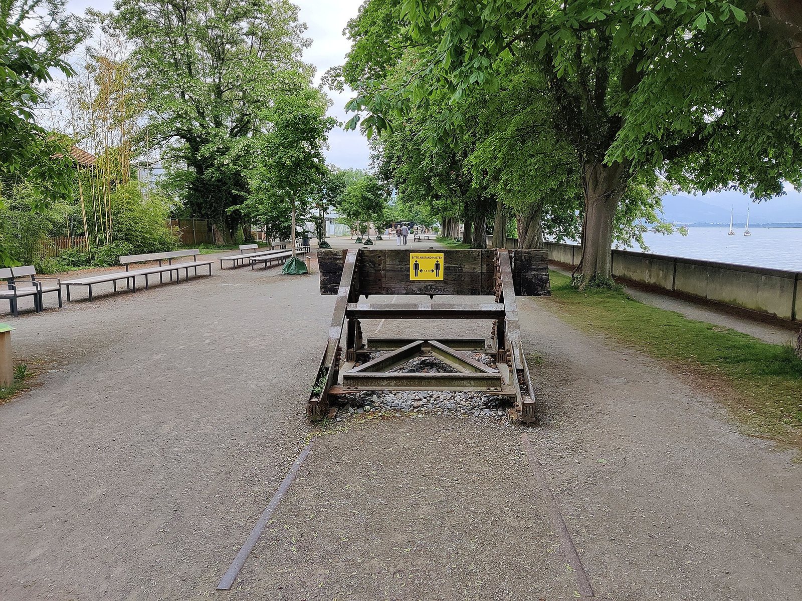 Promenade mit Bäumen und Holzobjekten auf der Hinteren Insel in Lindau